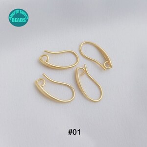 May include: Four gold-toned earring hooks, also known as ear wires, are shown on a white surface. The hooks are all in the same shape and size. The text '#01' is visible in the bottom centre of the image.