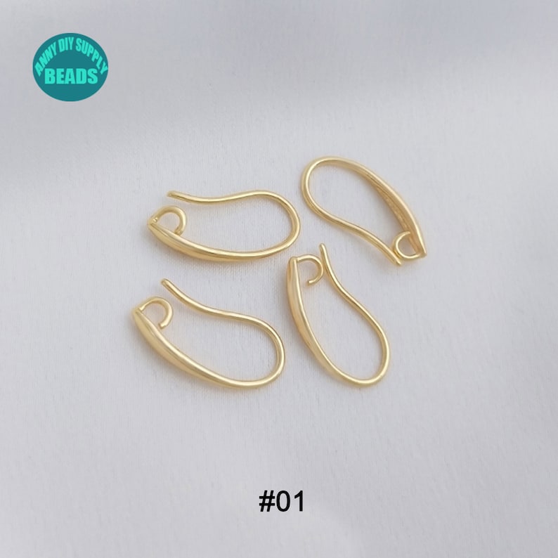 May include: Four gold-toned earring hooks, also known as ear wires, are shown on a white surface. The hooks are all in the same shape and size. The text '#01' is visible in the bottom centre of the image.