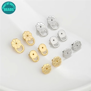 Peut inclure: Un ensemble de 10 dos d'oreille en or et argent. Les dos sont en forme de fleur avec un petit trou au centre. Les dos sont utilisés pour fixer les boucles d'oreilles à l'oreille.