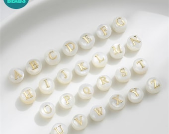 May include: White round beads with gold letters spelling out the alphabet A through Z.