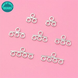 May include: Seven silver-toned metal connector pieces with three loops and a bar. The connector pieces are designed for jewelry making.