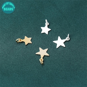 May include: Four star-shaped charms, two gold and two silver, with jump rings for attaching to jewelry or other crafts.
