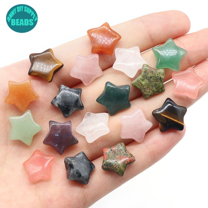 May include: Assortment of 15 star-shaped gemstone beads in various colours, including green, red, brown, black, and pink. The beads are arranged on a hand.