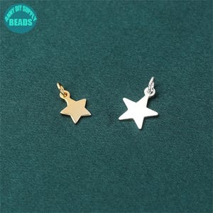 May include: Two star-shaped charms, one gold and one silver, with a loop at the top for attaching to jewelry or other crafts.