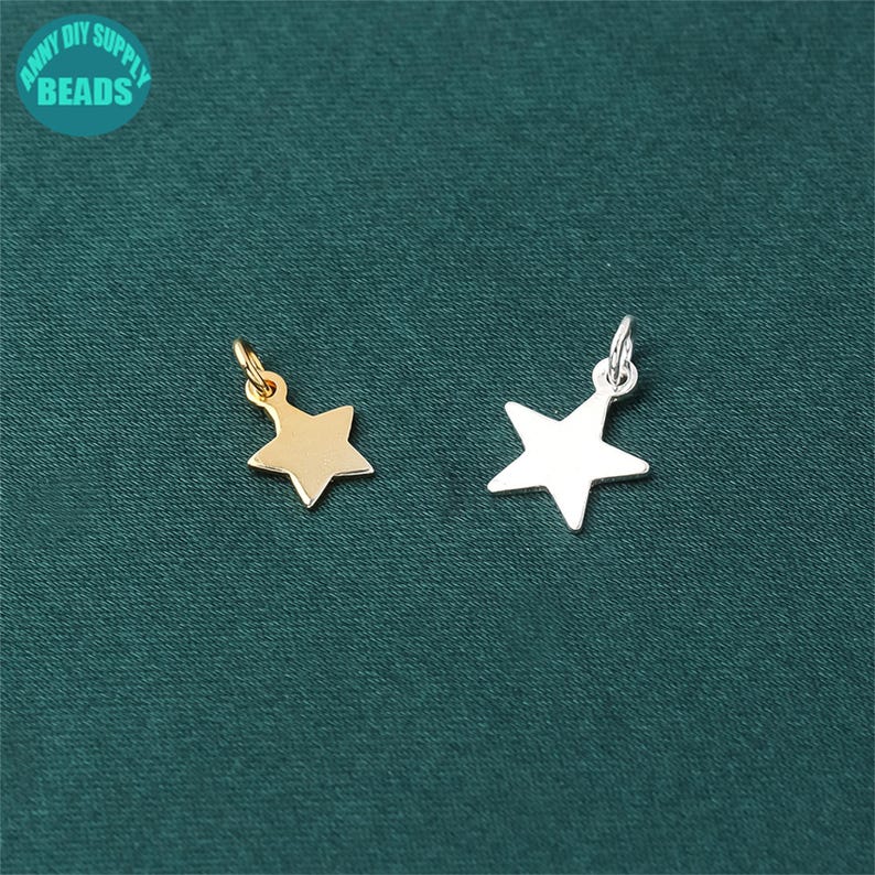 May include: Two star-shaped charms, one gold and one silver, with a loop at the top for attaching to jewelry or other crafts.