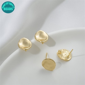 Op de afbeelding: Drie goudkleurige oorbel-bevestigingen met een gladde, afgeronde, ovale vorm. De bevestigingen zijn ontworpen om te worden gebruikt met verschillende oorbel-stijlen.