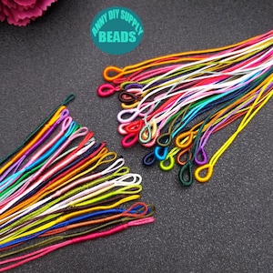 May include: Assortment of colorful, thin, knotted cords with loops at one end. The cords are arranged in two groups, with some overlapping. The cords are approximately 10 inches long.  The text "ANNY DIY SUPPLY BEADS" is visible in the image.