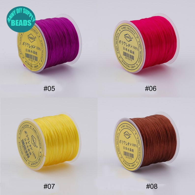 May include: Four spools of elastic cord in different colours: purple, red, yellow, and brown. Each spool has a label that reads "Polyurethane 100% Japan Crystal Line".