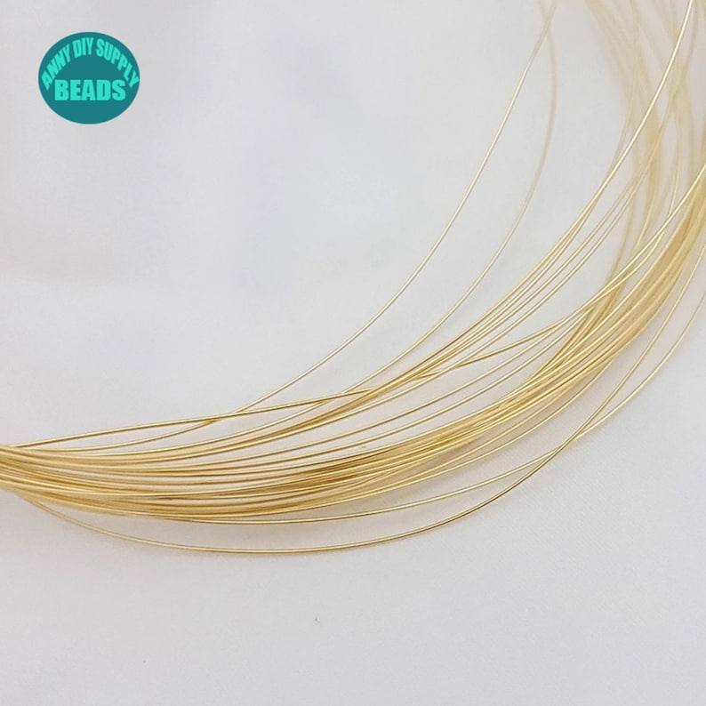 Pu&ograve; includere: Primo piano di un rotolo di filo color oro. Il filo &egrave; sottile e delicato, ed &egrave; avvolto strettamente attorno al rotolo. Il rotolo &egrave; fatto di un materiale plastico trasparente.