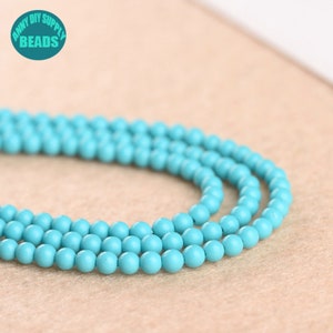 May include: A strand of turquoise blue round beads. The beads are smooth and uniform in size.