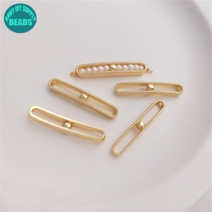 Könnte beinhalten: Fünf goldfarbene Metall-Stangenverbinder mit einer kleinen runden Perle in der Mitte. Ein Verbinder hat eine Reihe kleiner weißer Perlen.