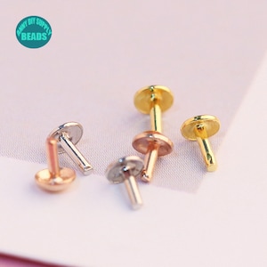 May include: Four metal studs in gold, silver, and rose gold. The studs have a flat round top and a short post.