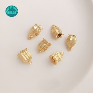 May include: Six gold-coloured metal flower charms with a textured surface. The charms have a loop at the top for attaching to jewellery or other crafts.