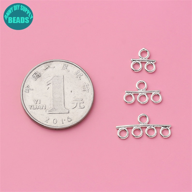 May include: Three silver-toned metal jewelry connectors with three loops each. The connectors are arranged in a row from top to bottom, with the top connector having two loops, the middle connector having three loops, and the bottom connector having four loops. A Chinese yuan coin is included for size comparison.