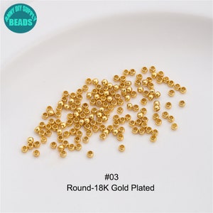 May include: A close-up image of a pile of small, round, gold-plated beads. The beads are scattered on a white surface. The text "#03 Round-18K Gold Plated" is visible below the beads.