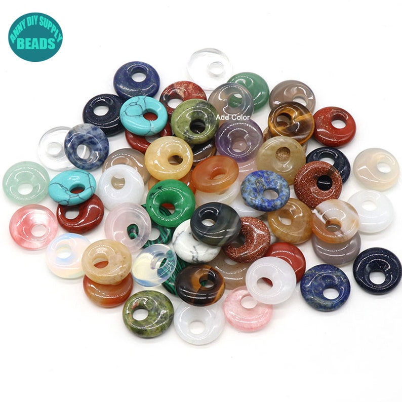 Puede incluir: Una colecci&oacute;n de cuentas de piedras preciosas de forma de donut de colores variados. Las cuentas est&aacute;n hechas de varias piedras naturales, incluyendo turquesa, amatista, ojo de tigre y cuarzo rosa.  Add Color.