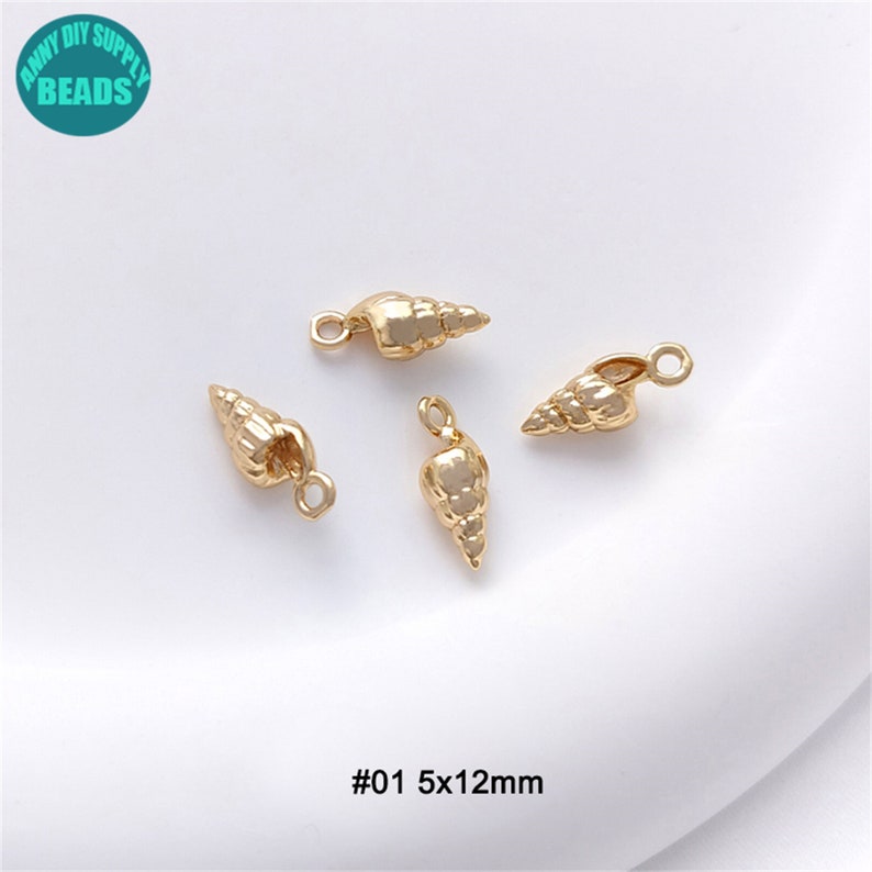 Puede incluir: Cuatro abalorios de concha de mar de color dorado con un bucle para sujetar a las joyas. Los abalorios miden aproximadamente 5 mm de ancho y 12 mm de largo. #01 5x12mm
