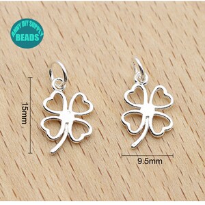 May include: Two silver four-leaf clover charms with a jump ring for attaching to jewelry. The charms are 1.5 inches tall and 0.95 inches wide.