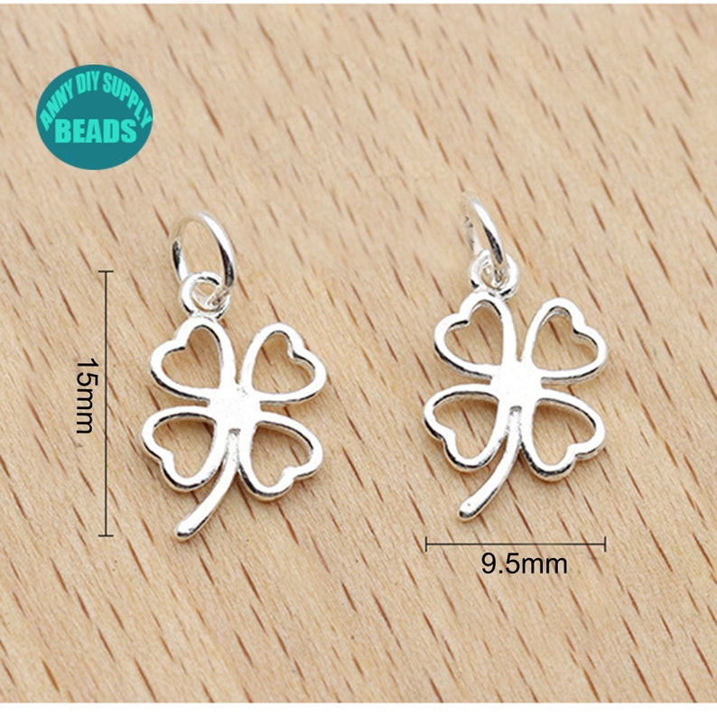 May include: Two silver four-leaf clover charms with a jump ring for attaching to jewelry. The charms are 1.5 inches tall and 0.95 inches wide.