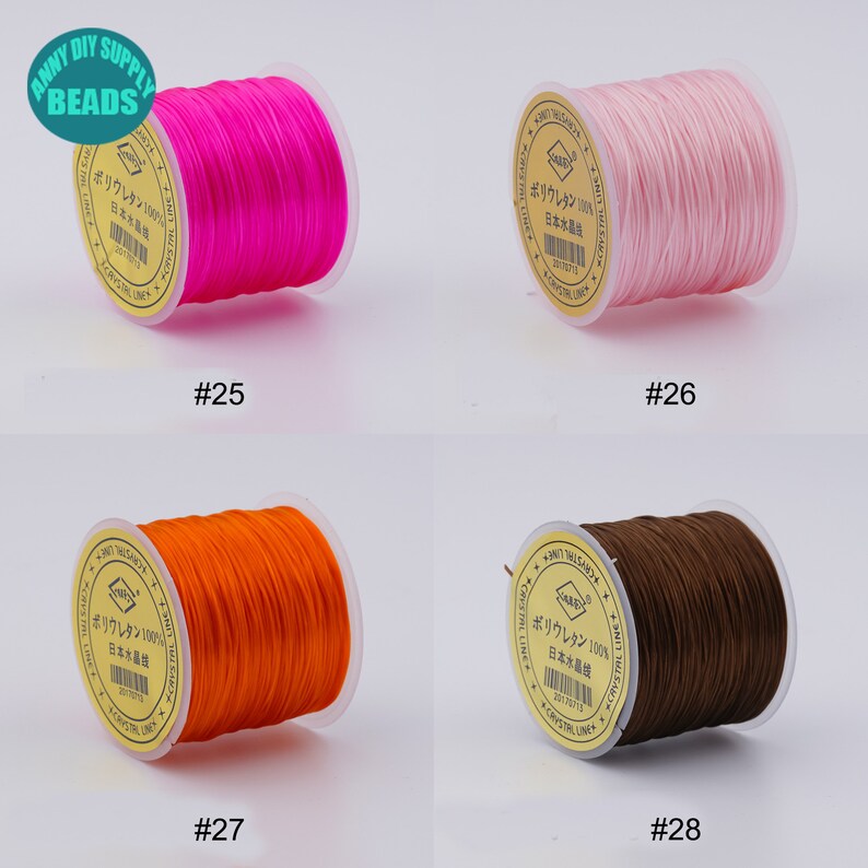 May include: Four spools of elastic string in different colours: pink, light pink, orange, and brown. Each spool has a label with Japanese text that says "Polyurethane 100% Made in Japan".