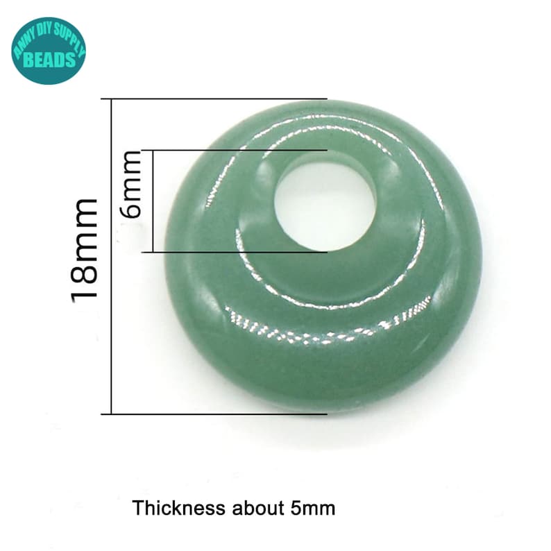 Puede incluir: Una cuenta de color verde claro en forma de rosquilla con un agujero en el centro. La cuenta tiene 18 mm de di&aacute;metro y 6 mm de grosor.