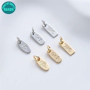 Könnte beinhalten: Sechs silberne und goldene Anhänger mit floralen Designs. Die Anhänger sind rechteckig und oval geformt mit einer Öse oben zum Anbringen an Schmuck.