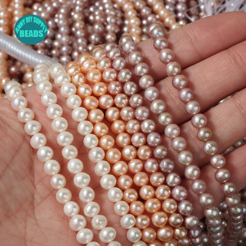 May include: A strand of white pearls, a strand of light pink pearls, a strand of peach pearls, and a strand of lavender pearls. The pearls are all round and smooth.