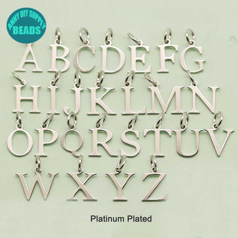 May include: A set of 26 silver-plated alphabet letter charms, each letter is on a separate charm. The charms are arranged in alphabetical order. The charms are platinum plated.