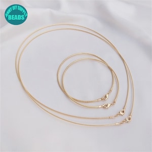 Puede incluir: Cuatro cadenas de serpiente doradas de diferentes longitudes, todas con cierres de langosta.