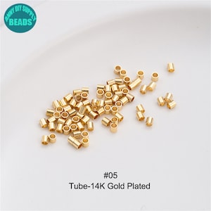 May include: A close-up image of a pile of small, gold-plated metal tubes. The tubes are approximately 6mm in diameter and 12mm long. The image is labelled with the text "#05 Tube-14K Gold Plated".