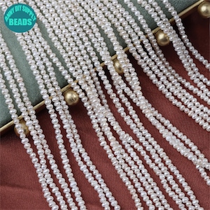 Può includere: Primo piano di una collana di perle d'acqua dolce bianche. Le perle sono piccole e rotonde, e sono infilate su un filo sottile. Le perle sono disposte in una fila ordinata, e sono tutte della stessa dimensione. Le perle sono di un bel colore bianco, e hanno una finitura liscia e lucida.