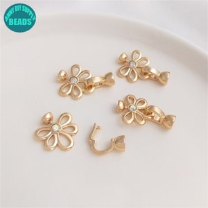Puede incluir: Cinco cierres de flores de color dorado con diamantes de imitación transparentes. Cada cierre tiene un gancho en un lado y un bucle en el otro.