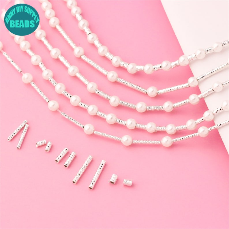 May include: Five strands of white pearl beads with silver spacer beads. The beads are strung on silver wire. There are also ten silver end caps.