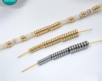 May include: Three strands of beads in gold and silver tones. One strand features small, round, silver beads. Another has gold-colored beads, and the third has a mix of white and gold beads. The beads are strung on thin, gold-colored wires.