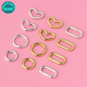 May include: Assortment of silver and gold metal heart and oval shaped clasps. The clasps are open and ready to be attached to jewellery or other crafts.