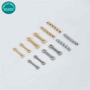 May include: A selection of gold and silver-toned jewellery-making beads. The image shows twisted connector beads and textured bars. A teal circular logo with the text "ANNY DIY SUPPLY BEADS" is also visible.