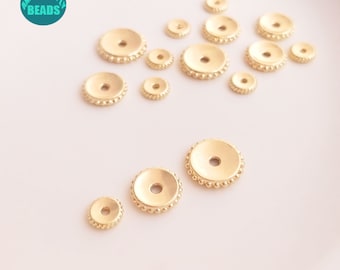 May include: A collection of gold-toned metal bead caps with a beaded edge. The bead caps are of various sizes and are arranged on a white surface.