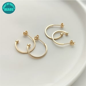 Peut inclure: Trois boucles d'oreilles créoles dorées au design simple. Les boucles d'oreilles sont en métal et ont une finition lisse.