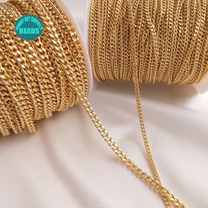 May include: A spool of gold-colored curb chain, with a section of the chain laid out straight. The chain is made of metal and has a shiny finish. The spool is labeled "Funny DIY Supply Beads".