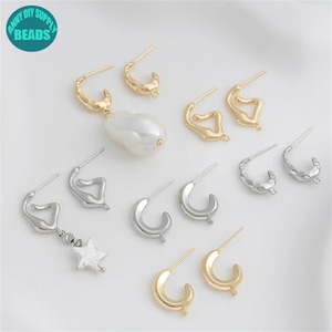 Könnte beinhalten: Ein Set mit 8 goldenen und silbernen Ohrringen. Die Ohrringe haben verschiedene Formen und Größen. Einige der Ohrringe haben eine strukturierte Oberfläche. Die Ohrringe liegen auf einem weißen Hintergrund.