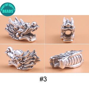 May include: Silver dragon head charm with intricate details. The charm is shown from four different angles, including the front, side, and back. The charm is a popular choice for jewelry making and crafting.