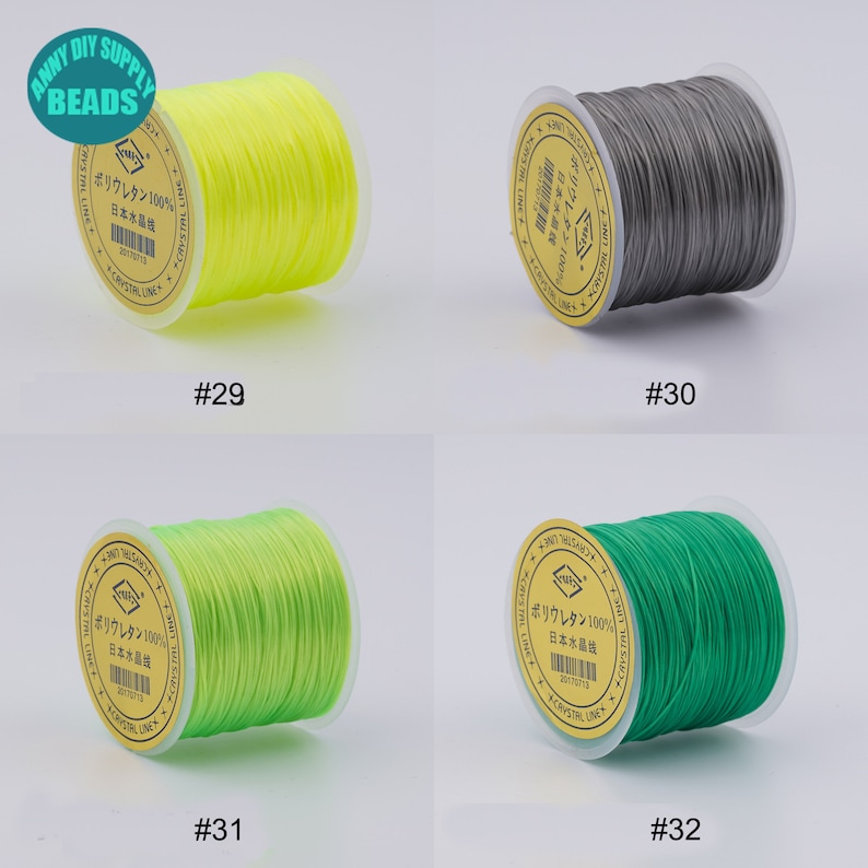 May include: Four spools of elastic string in different colours: yellow, grey, green, and lime green. Each spool has a label with Japanese text that says "Polyurethane 100% Japan Crystal Line".