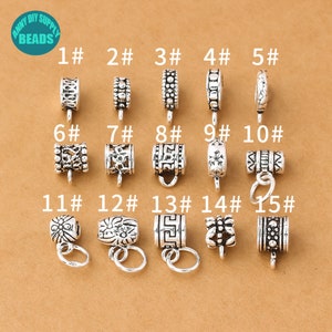 May include: Fifteen silver-toned metal bead caps with various designs. The bead caps are numbered 1 through 15.