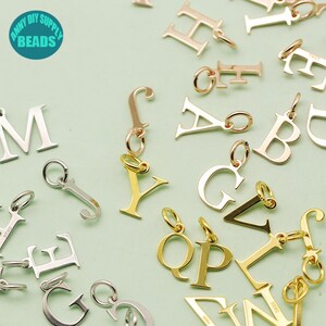 May include: Assortment of gold, silver, and rose gold letter charms. The charms are in the shape of the letters A, B, C, D, E, F, G, H, I, J, K, L, M, N, O, P, Q, R, S, T, U, V, W, X, Y, and Z. The charms are perfect for adding a personal touch to jewelry.