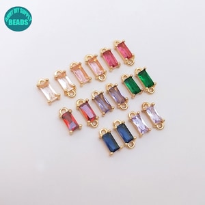 May include: Assortment of 12 gold-tone connector charms with colorful rectangular crystal accents. Each charm has two jump rings for attaching to jewelry.