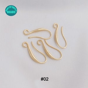 May include: Five gold-toned metal earring hooks, each with a smooth, slightly curved design. The hooks are arranged in a loose cluster on a white background. The text '#02' is printed below the hooks.