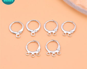 May include: Six silver earring hoops with three jump rings on each hoop. The hoops are all the same size and are arranged in a semi-circle.