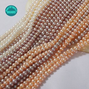 May include: A strand of multiple colors of freshwater pearls. The pearls are round and have a smooth, iridescent finish. The colors range from white to pink to purple.