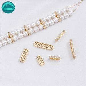 Può includere: Ciondoli connettore in metallo dorato con accenti di cristallo trasparente. Alcuni ciondoli hanno un design geometrico. I ciondoli sono sparsi su una superficie bianca.  "AMNY DIY SUPPLY BEADS" è stampato su un cerchio blu.