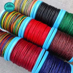 May include: Six spools of waxed cotton cord in various colors, including rainbow, red, burgundy, black, green, and blue. The spools are wrapped in blue plastic.